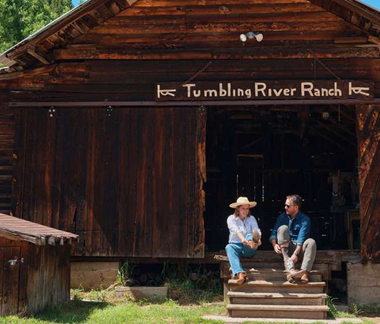 People sitting on the steps of a barn